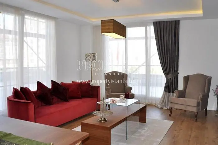 Red sofa and two brown armchairs in the living room in Arifoglu Residence