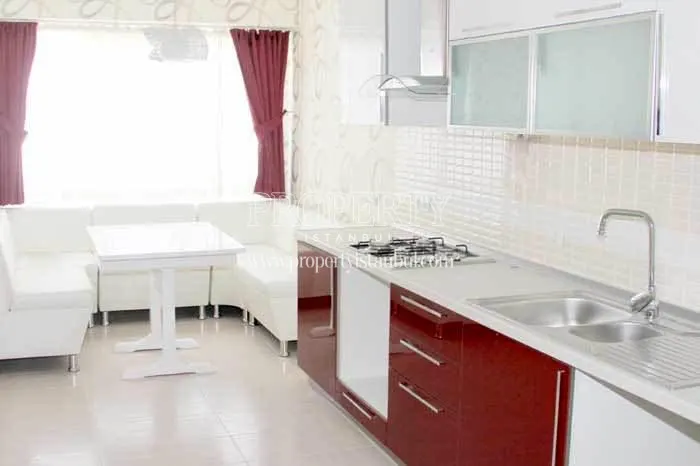 Red and white furnished kitchen in Aris Park Residence