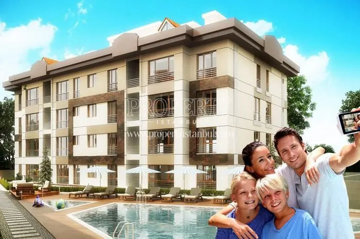 The happy family taking a picture in front of the swimming pool in Aydogan Park Tuzla compound