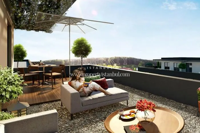 A woman reading a book while her baby is sitting on her lap on the balcony in Gaia Premium Houses