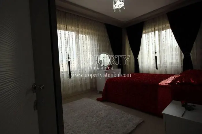 Red bed cover in one of the bedrooms in Mavera Konutlari