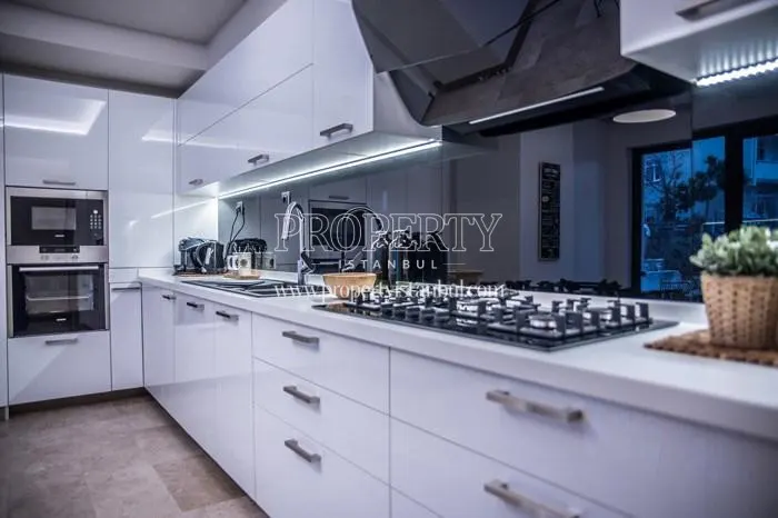 The kitchen with white cabinets in one of the flats in Olive Sariyer Evleri