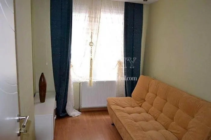 Yellow couch with dark blue curtains in a quite small living room in Propa Plus Residence