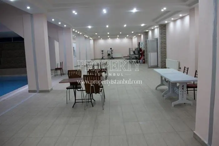 Table and chairs near the swimming pool in Propa Plus Residence