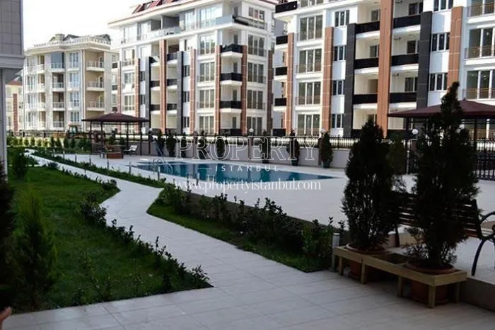Outdoor swimming pool among the buildings in the Pinartepe Residence compound