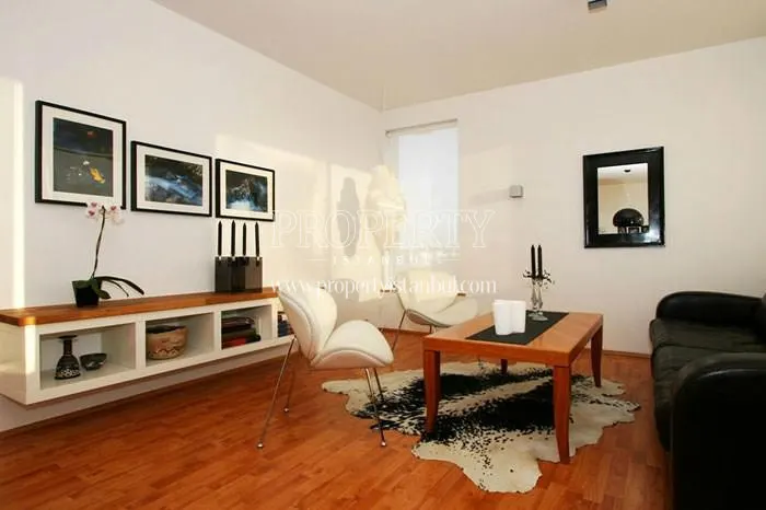 Black sofa with two white chairs in one of the Rose Garden Gurpinar apartments