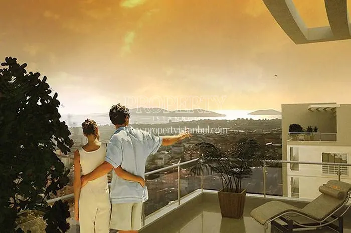 A couple viewing the sea from their balcony in Twinstar Yakacik