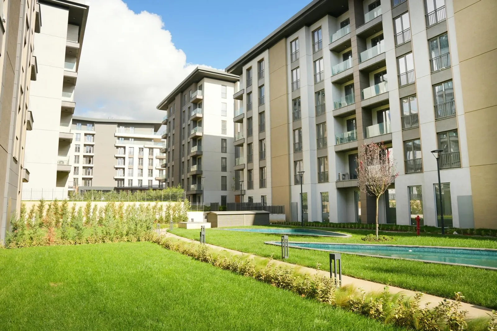 Lawns and pool between the Emlak Konut Cinarkoy Evleri blocks