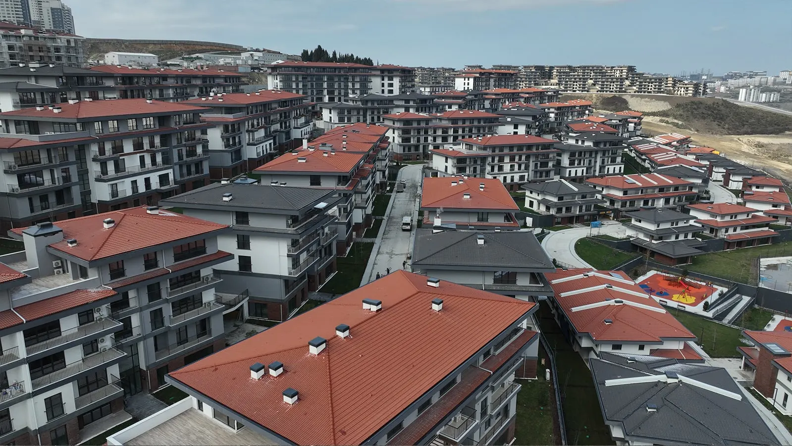 Red-roofed blocks and a playground at Emlak Konut Vadi Evleri