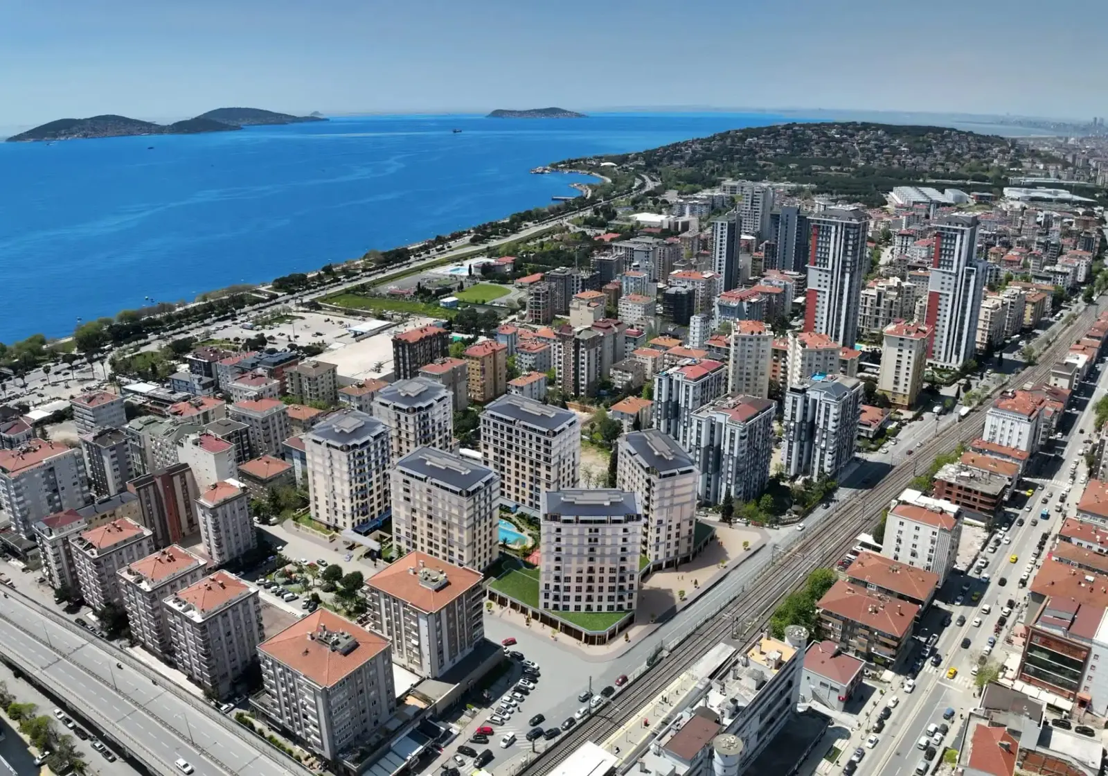 Tria Kordonboyu blocks beside the Marmaray line, with the sea and the Princes' Islands behind